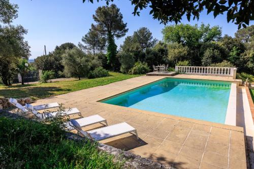 une piscine avec deux chaises longues et une piscine dans l'établissement Villa les Lilas, à La Colle-sur-Loup