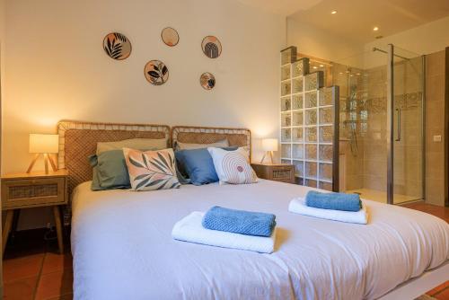 une chambre avec un grand lit blanc avec des oreillers bleus dans l'établissement Villa les Lilas, à La Colle-sur-Loup