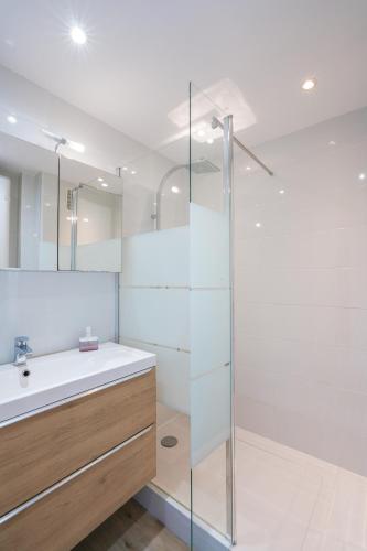 une salle de bain avec une douche en verre et un lavabo dans l'établissement Appart vue mer - Proche Monaco, à Beausoleil