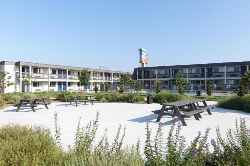a group of picnic tables in front of a building at Motel 6-Claremont, CA in Claremont