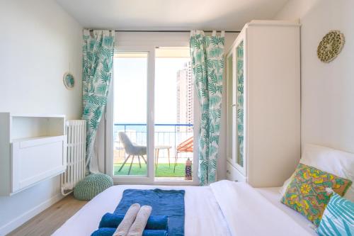 une chambre avec un lit et une grande fenêtre dans l'établissement Appart vue mer - Proche Monaco, à Beausoleil