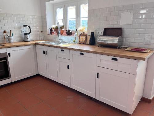 a kitchen with white cabinets and a counter top at Herdade do Vidigal in Montemor-o-Novo
