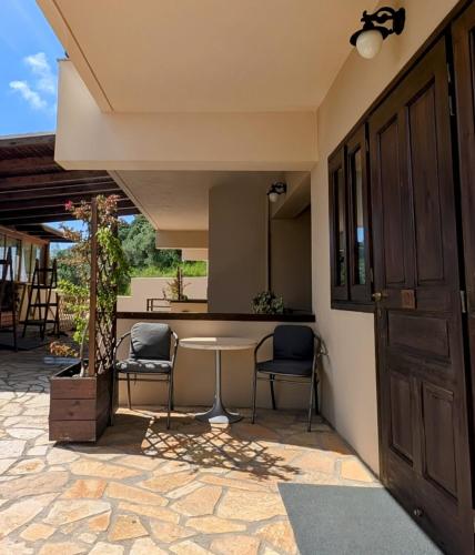 a patio with a table and chairs in a house at Althea Apartments in Katakolon
