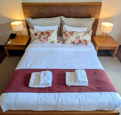 a bedroom with a bed with two towels on it at Althea Apartments in Katakolon
