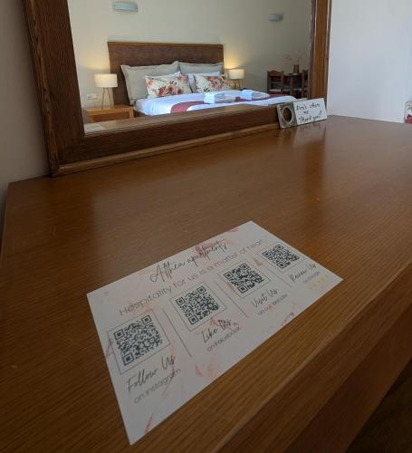 a sign on a table with a bed in a mirror at Althea Apartments in Katakolon