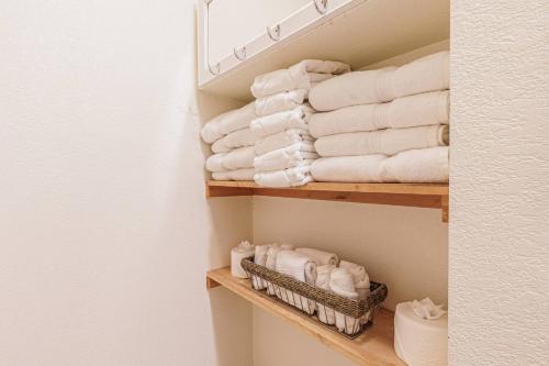 a bunch of towels on a shelf in a bathroom at Whispering Pines Cabin in Whittier