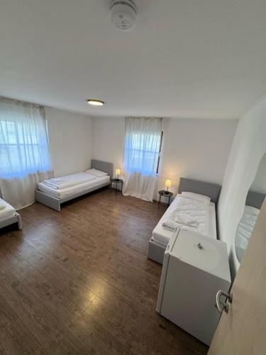 a large room with two beds and two windows at Bavaria Home Rohrbach in Rohrbach