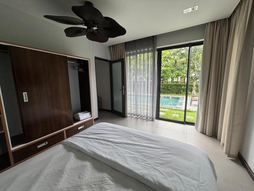 a bedroom with a bed and a ceiling fan at M Beach Luxury Villas Phu Quoc 2 in Phu Quoc