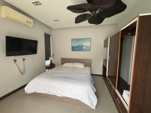a bedroom with a bed and a ceiling fan at M Beach Luxury Villas Phu Quoc 2 in Phu Quoc