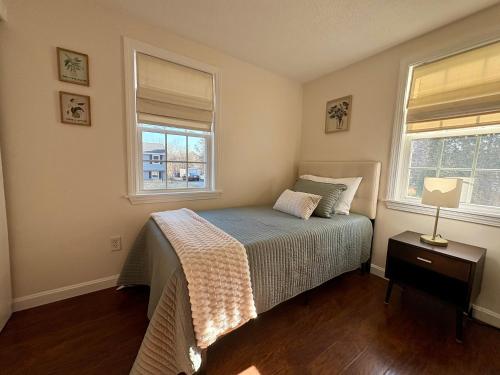 a bedroom with a bed and two windows at The Perfect Restful Retreat in Wareham