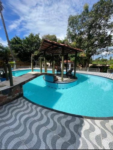 a large swimming pool with a gazebo at Hotel Pérolas Beach in Paracuru