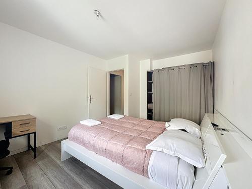 une chambre blanche avec un lit et un bureau dans l'établissement Maison spacieuse tout équipée Dolet, à Clermont-Ferrand