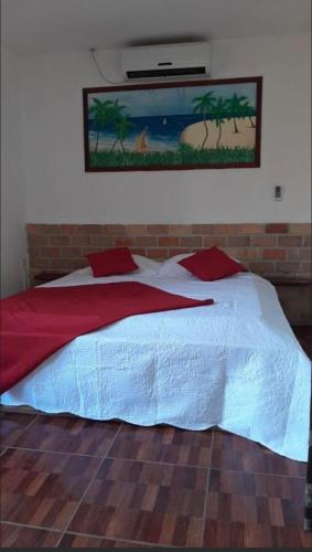 a bedroom with a large bed with a painting on the wall at Hotel Pérolas Beach in Paracuru