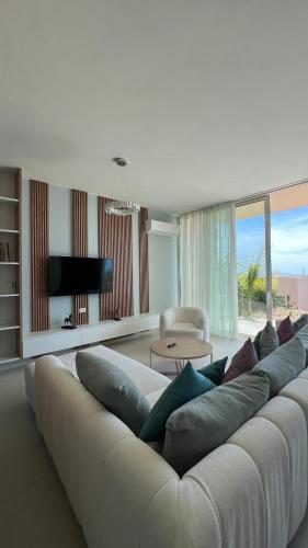 a large white couch in a living room at MIKU Green Coast in Palasë
