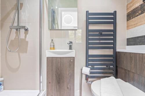 a bathroom with a toilet and a sink and a shower at Contemporary Comfort Steps from Ricoh Arena in Coventry