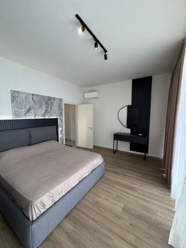 a bedroom with a bed and a black chair at MIKU Green Coast in Palasë