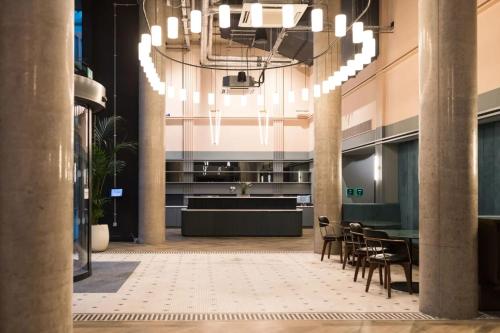 a lobby with a chandelier and a table and chairs at Chapter Spitalfields in London in London