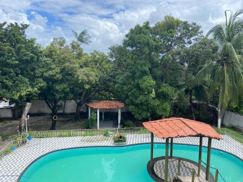a swimming pool in a yard with trees at Hotel Pérolas Beach in Paracuru