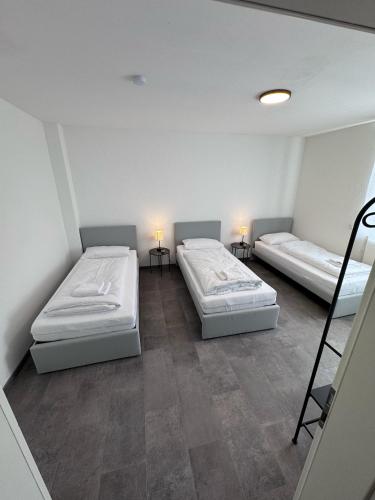 two beds in a small room with two lamps at Bavaria Home Apartment Rohrbach in Rohrbach