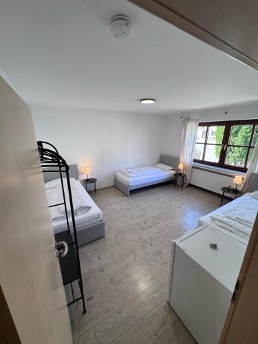 a room with two bunk beds and two tables at Bavaria Home Apartment Rohrbach in Rohrbach