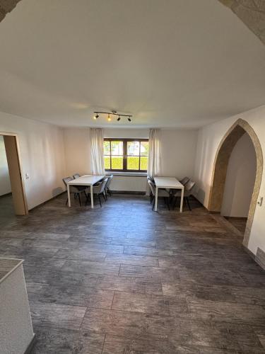 an empty room with two tables and a window at Bavaria Home Apartment Rohrbach in Rohrbach