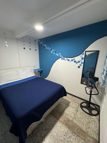 a bedroom with a bed with a blue and white wall at Casa Cristal in Mexico City