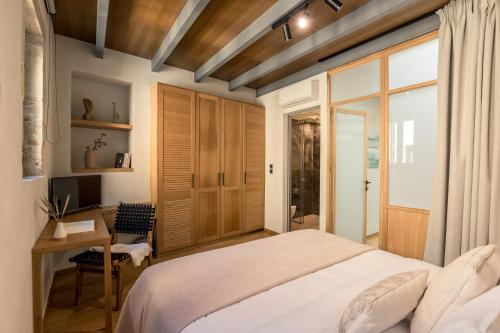 una camera da letto con un letto, una scrivania e una televisione di The Peach House a Chania