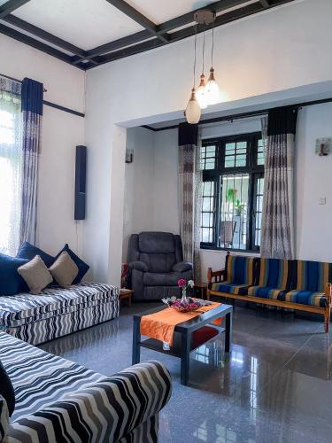 a living room with couches and a coffee table at Serenity Home Stay in Kandy