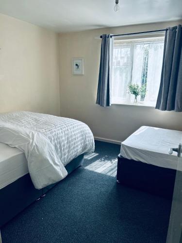 a bedroom with two beds and a window at Central Upton Upon Severn 2 bedroom property sleeps 6 in Upton upon Severn