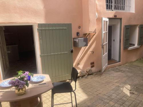 a room with a table and a door and a table and chairs at La Tanière du Ventoux in Bédoin
