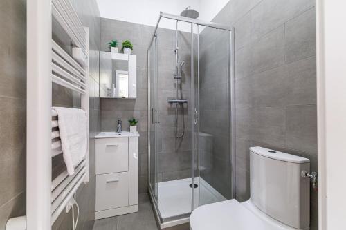 La salle de bains est pourvue d'une douche et de toilettes blanches. dans l'établissement Lumière Azuréenne, à Villeneuve-Loubet