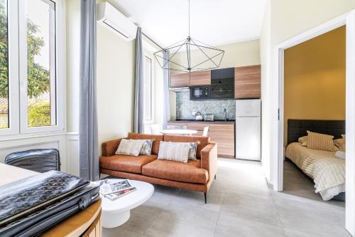 un salon avec un canapé et un lit dans l'établissement Lumière Azuréenne, à Villeneuve-Loubet