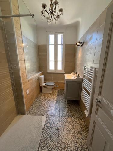 La salle de bains est pourvue de toilettes, d'un lavabo et d'un lustre. dans l'établissement Treignac, à Treignac