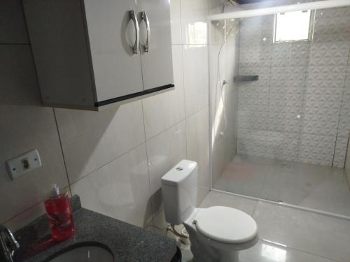 a small bathroom with a toilet and a shower at Pousada Bella Montanha in Louro Müller