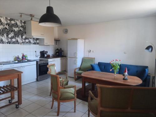 une cuisine et un salon avec une table et des chaises dans l'établissement Keranna, une maison entre rivière et forêt, à La Forest-Landerneau