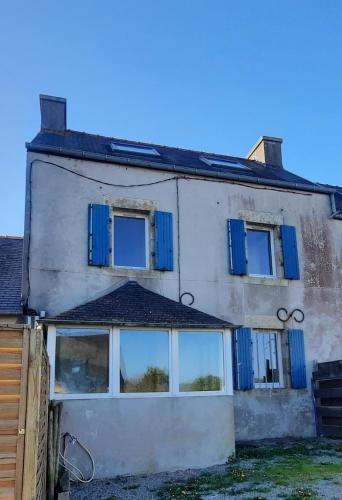 une vieille maison avec des volets et des fenêtres bleus dans l'établissement Keranna, une maison entre rivière et forêt, à La Forest-Landerneau