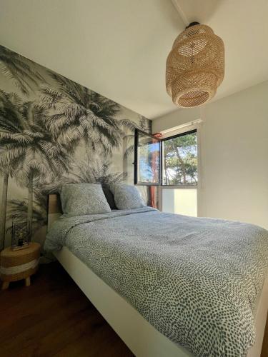 - une chambre avec un lit orné d'une fresque murale de palmiers dans l'établissement Douce brise proche océan, à Seignosse