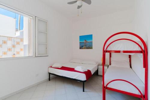 a bedroom with two bunk beds and a window at Villino Airone in Torre Lapillo