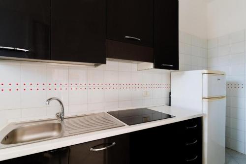 a kitchen with a sink and a refrigerator at Villino Airone in Torre Lapillo