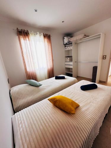 MigliacciaroL Alba Serena的一间卧室配有两张床,上面有黄色枕头