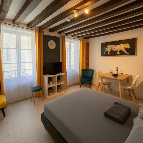 une chambre avec un lit, une table et des chaises dans l'établissement Appartement Vue Cathédrale- Centre ville Meaux-Gare-Disney, à Meaux