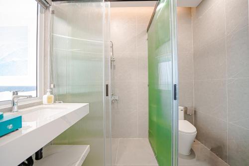 a bathroom with a shower and a sink and a toilet at Lotus Sầm Sơn Hotel in Sầm Sơn