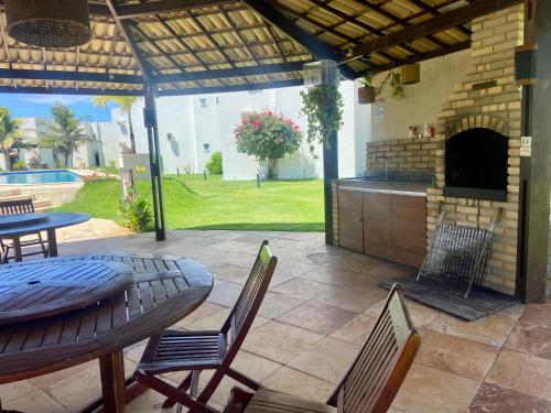 a patio with a table and chairs and a brick oven at Casa Paraiso Beira-Mar in Maracajaú