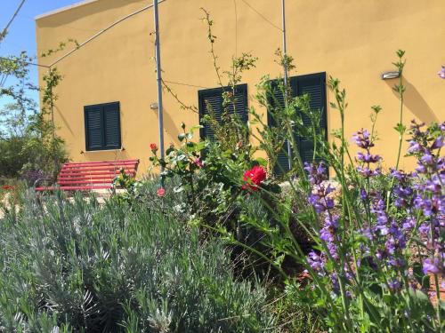 a garden with flowers and a building with windows at Agriturismo Mele in Copertino