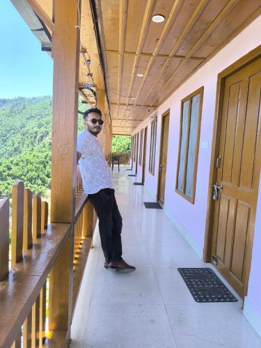 a man sitting on a bench in a hallway at Veda Inn in Chakrāta