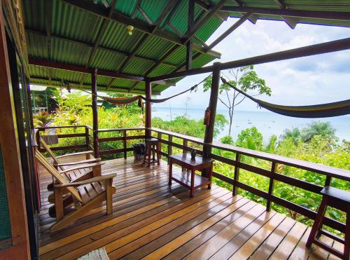 a wooden deck with chairs and a view of the ocean at Corcovado The Monkey Trail in Drake