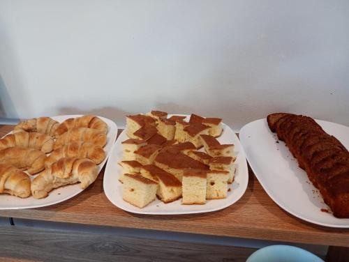 three plates with different types of bread and a sausage at Hotel El Paraiso Boutique in Villa Carlos Paz