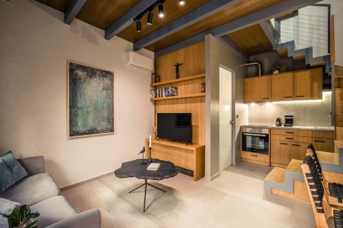 un soggiorno con divano e TV e una cucina di The Peach House a Chania