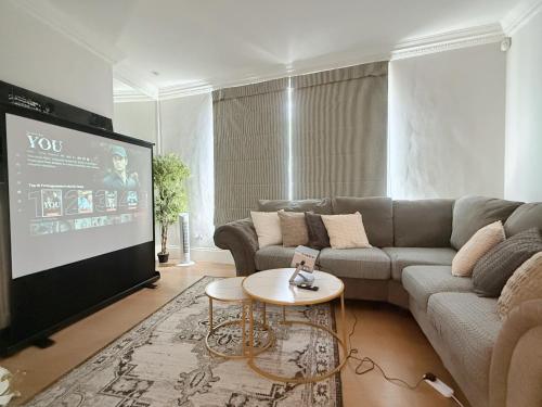 a living room with a couch and a tv at Spacious and cosy 3BRs 5F House in Heart of London in London