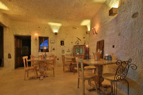 ギョレメにあるThe Owl Cave Hotelの建物内のテーブルと椅子のあるダイニングルーム